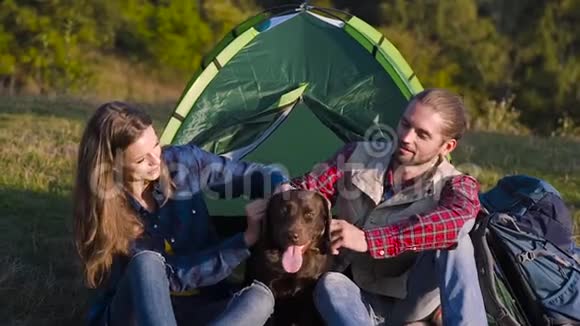 男人和女人带着狗在营地旅行视频的预览图