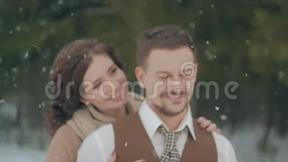 可爱的一对夫妇在冬天的圣诞公园散步大雪视频的预览图