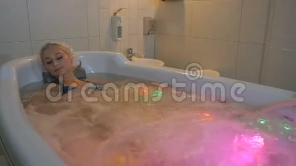 有魅力的女士在淋浴帽享受与气泡的水文分析视频的预览图