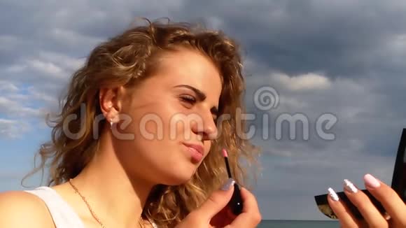 美丽的女孩年轻的卷发化妆品海洋视频的预览图