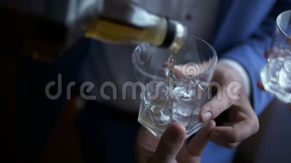 优雅的商人把威士忌倒进玻璃杯里视频的预览图