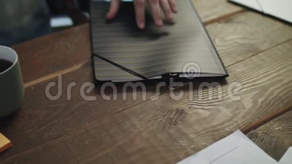 男性手打开文件夹在会议桌上拿到纸质文件视频的预览图