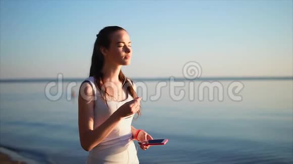 年轻漂亮的女人用耳机听音乐视频的预览图