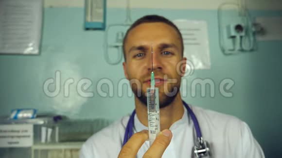 年轻的白种人医生从注射器里倒出一种液体并微笑的肖像医务工作者准备注射器视频的预览图