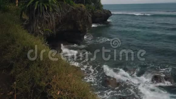 努沙杜瓦海岸线的景观岩石明亮的植被蔚蓝的海洋视频的预览图