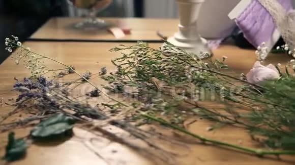 慢镜头显示木制桌子的花剪刀磁带装饰纸和其他花束工具视频的预览图