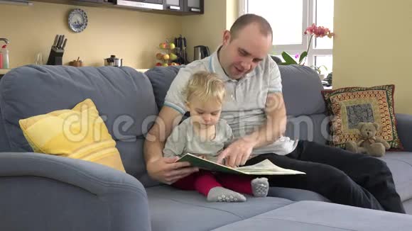 可爱的父亲和他的孩子在家读故事书视频的预览图