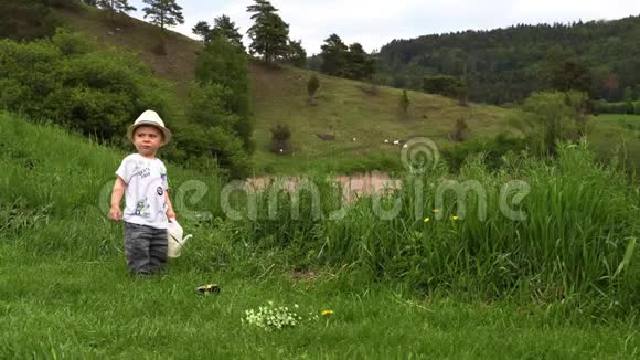 一个戴着白帽子的小男孩在田野里玩花田视频的预览图
