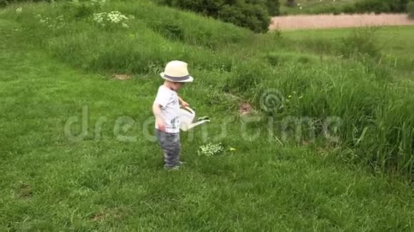 一个戴着白帽子的小男孩在田野里玩花田视频的预览图