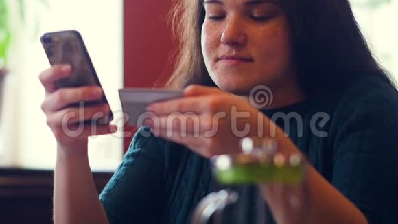 年轻女性使用智能手机上网购物视频的预览图