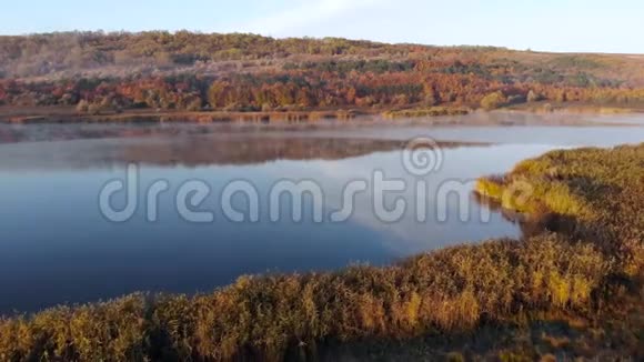 飞越一个湖水面上有雾早晨雾霭朦胧雾霭笼罩湖面秋天的薄雾秋天视频的预览图