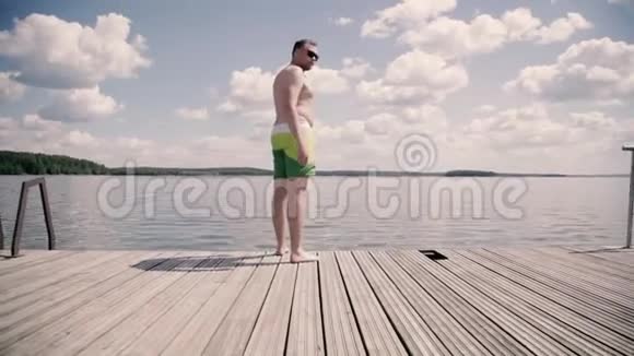超重的家伙在夏天的湖上潜水视频的预览图