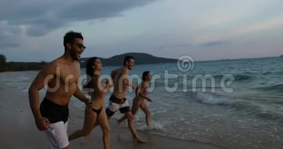 在夕阳下的沙滩上人们在海上嬉戏在度假时与欢乐的朋友打成一片视频的预览图