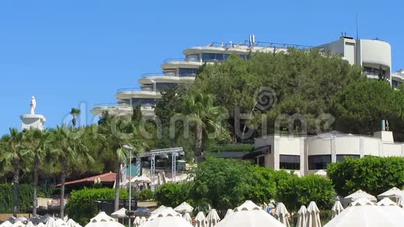 豪华五星级酒店的全景窗户棕榈树环绕从海滩俯瞰视频的预览图