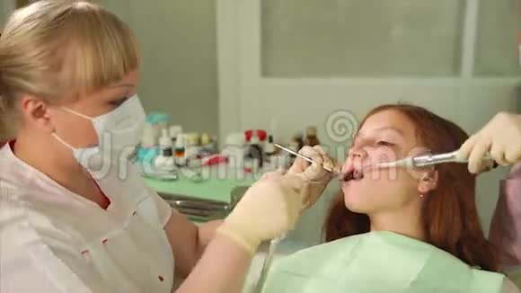 一位女牙医照顾一位来做牙齿矫正的青少年的牙齿视频的预览图