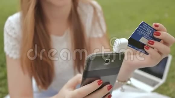 一个年轻的女孩在网上银行使用微型磁性移动读卡器付款视频的预览图