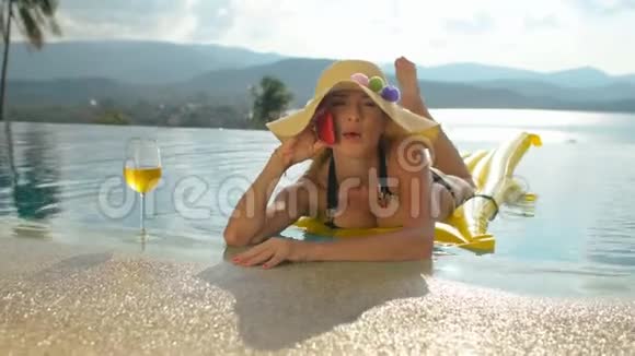 成功的女商人在游泳池里的充气床垫上放松视频的预览图