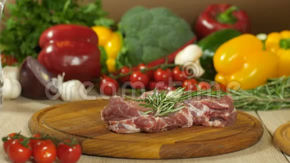 肉的宏观摄影一块多汁的生牛排用胡椒橄榄和新鲜的迷迭香厨师在视频的预览图