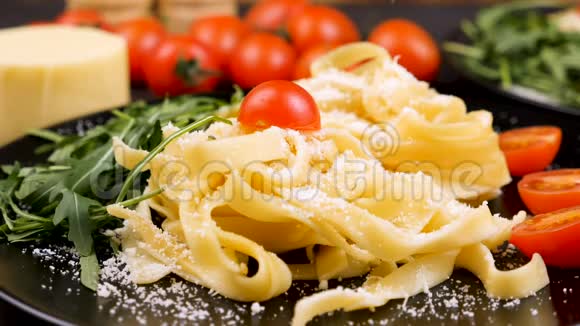 帕米森奶酪和塔格利亚特意大利面一起落在盘子里视频的预览图