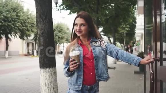 站在大街上喝咖啡的年轻女子视频的预览图