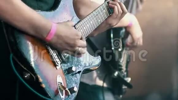 音乐家们在摇滚音乐节上演奏老式电吉他双手特写视频的预览图