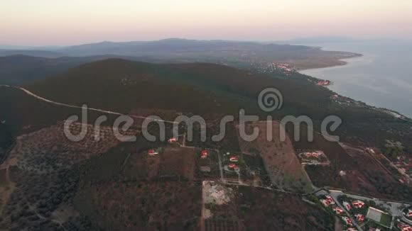在希腊沿海城镇的平原和山丘上飞过绿色的风景视频的预览图