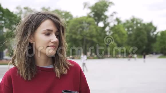 年轻的红衣女子喝着咖啡去公园视频的预览图