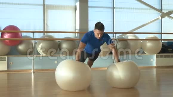 男人在健身房里对球做俯卧撑视频的预览图