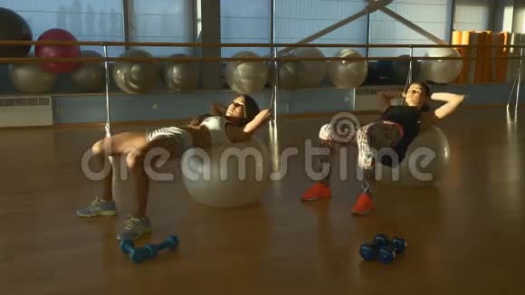 漂亮的女孩在健身房训练健身球视频的预览图
