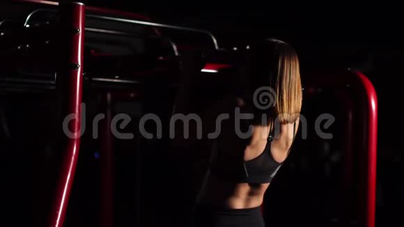一个美丽的女人在一个黑色的顶部一个开放的腹部将拉起带便携式大厅的节奏背景视频的预览图