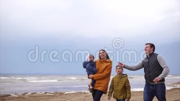 一天的假期友好的家庭在海滩上散步夫妻相爱视频的预览图
