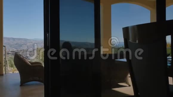 一个男人带着一只狗在现代别墅的露台上休息视频的预览图