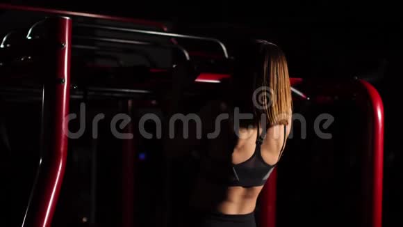 一个美丽的女人在一个黑色的顶部一个开放的腹部将拉起带便携式大厅的节奏背景视频的预览图
