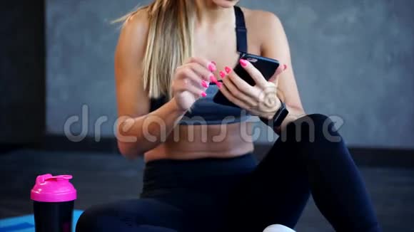 健身操后的女人她在智能手机上打字视频的预览图