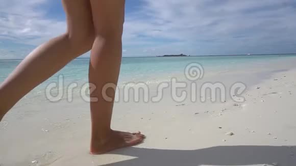 美丽的女人腿沿着马尔代夫的海滩散步视频的预览图