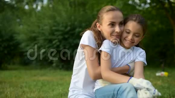 微笑志愿者和女孩在草地上拥抱视频的预览图