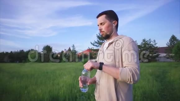 一个穿着运动服从塑料瓶里喝水的人视频的预览图