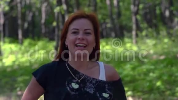 慢动作红头发女子特写一个红发年轻微笑的女人的肖像视频的预览图
