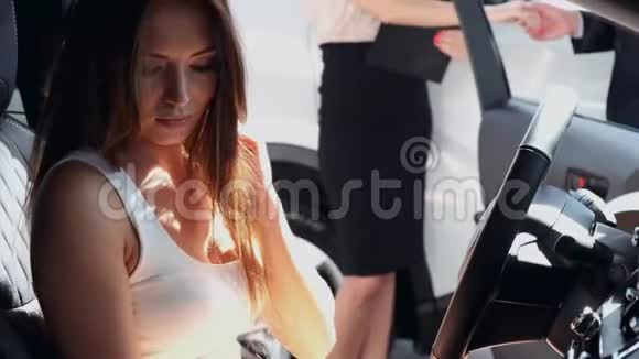 优雅的女人在汽车经销店试着开车视频的预览图
