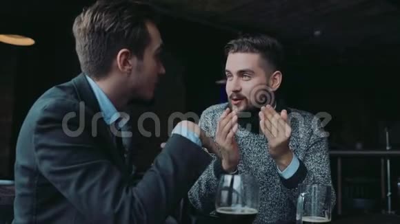 年轻的绅士在酒吧里玩得很开心积极地说话品尝着美味玛娜俱乐部男性传统积极的生活方式视频的预览图