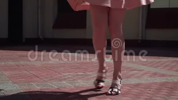 一个穿着粉红色裙子的女孩在院子里旋转镜头从女孩的腿上移开抓住了天空视频的预览图