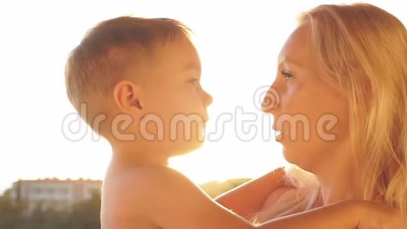 日落时分幸福的白种人家庭肖像在夕阳下嘲笑母子慢动作视频的预览图