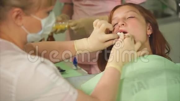 牙科医生在牙龈和牙齿之间插入绷带治疗口腔视频的预览图