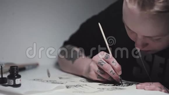 有纹身的艺术家朋克女人在台灯的书桌前画画视频的预览图