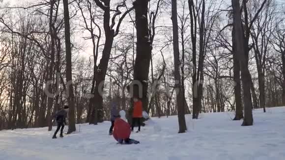孩子们在冬季公园堆雪人慢动作视频的预览图