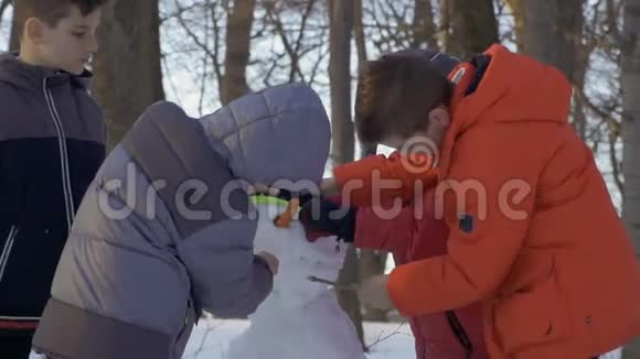 冬季公园里的男孩在慢动作地堆雪人视频的预览图