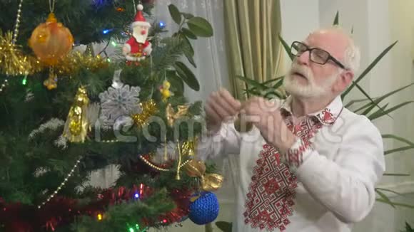 有魅力的老爷爷在家装饰圣诞树视频的预览图