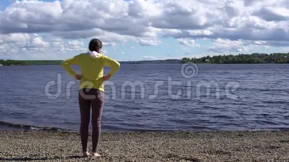一位年轻妇女白天在湖岸从事健身活动视频的预览图