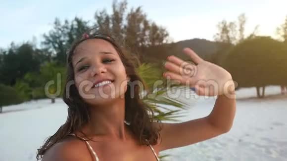 一位美丽的深黑色美女她住在热带海滩上拍着自拍手握相机还有一部录像带视频的预览图