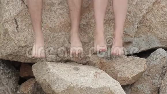 一个男人和一个女人光着脚在沙滩上踏着石头视频的预览图